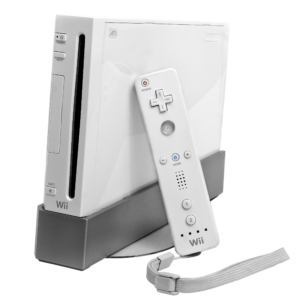 White Nintendo Wii console upright on its grey stand with a Wii Remote leaning against it